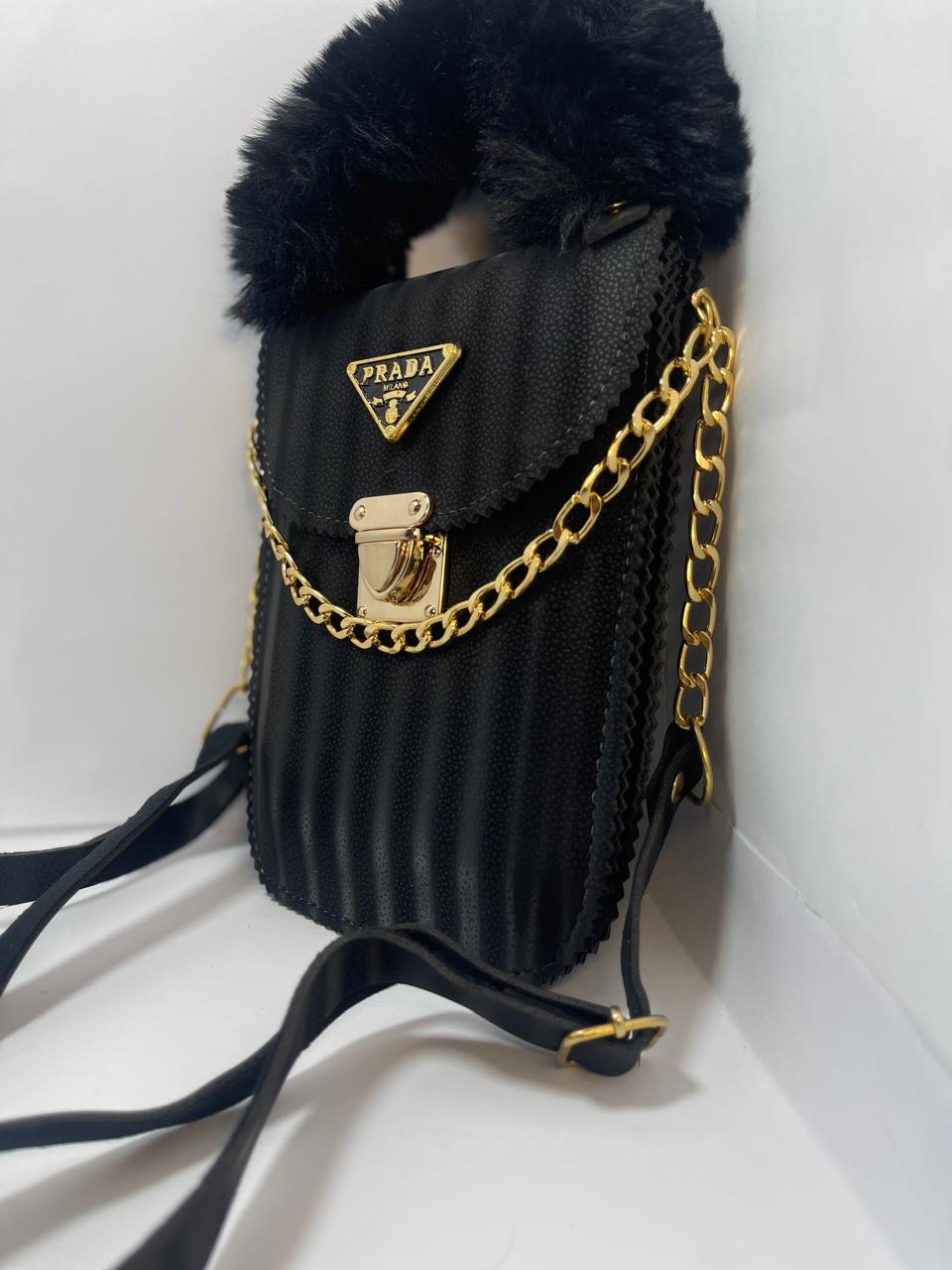 "Black Prada Handbag with Gold Chain Strap and Fluffy Handle"